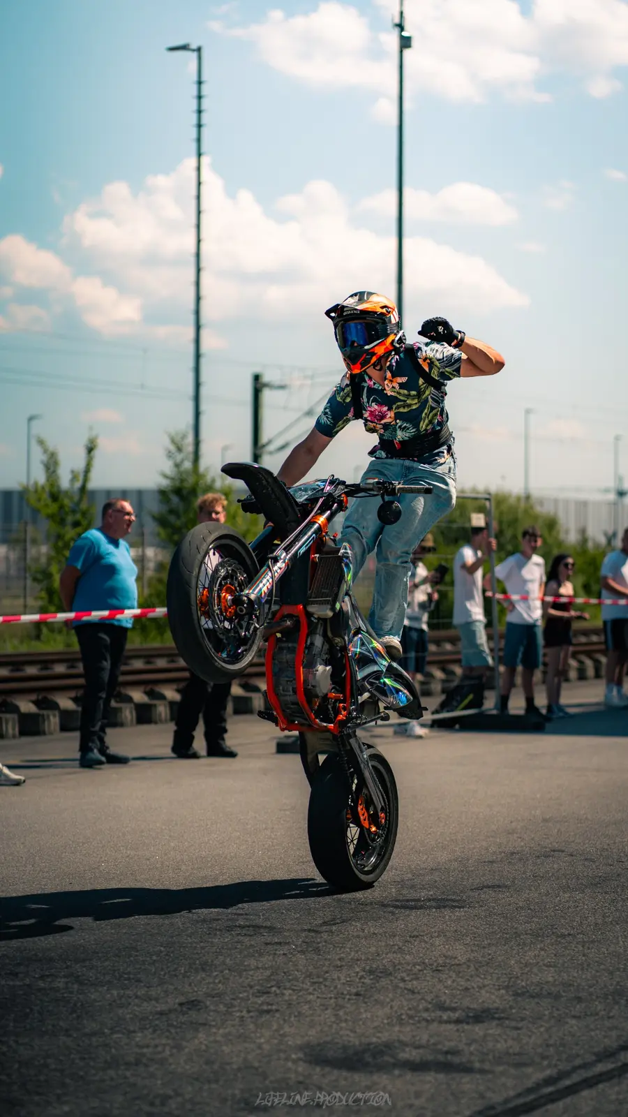 Stuntfahrer im Blumenhemd auf einem Motorrad